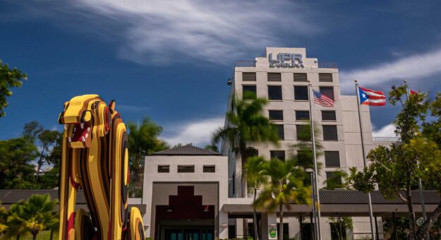 Fachada de la Universidad de Puerto Rico en Carolina con escultura de jaguar en frente
